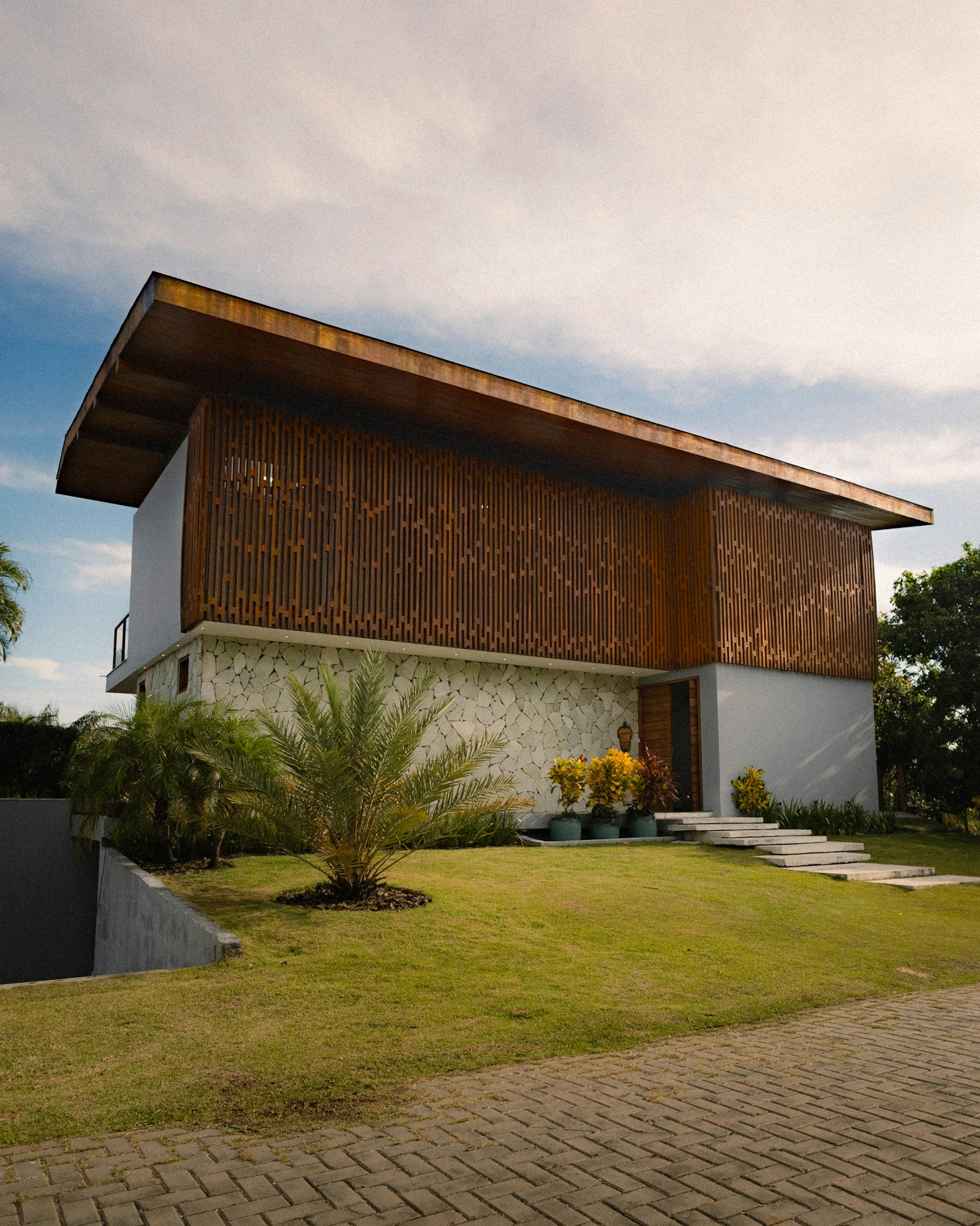 A contemporary home with a wood facade, large windows and green lawn